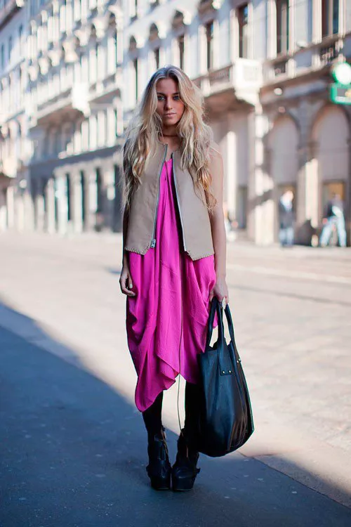 Девушка в длинном, фиолетовом платье с большой черной сумкой в руке