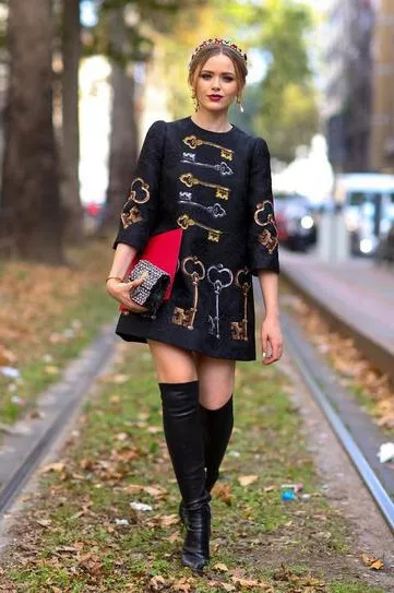 Девушка в очень модном, коротеньком платьице с принтами ключей и ботфортах
