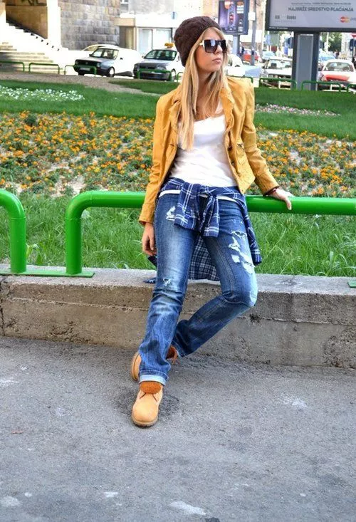 Девушка в рваных джинсах, коричневых тимберлендах и жакете