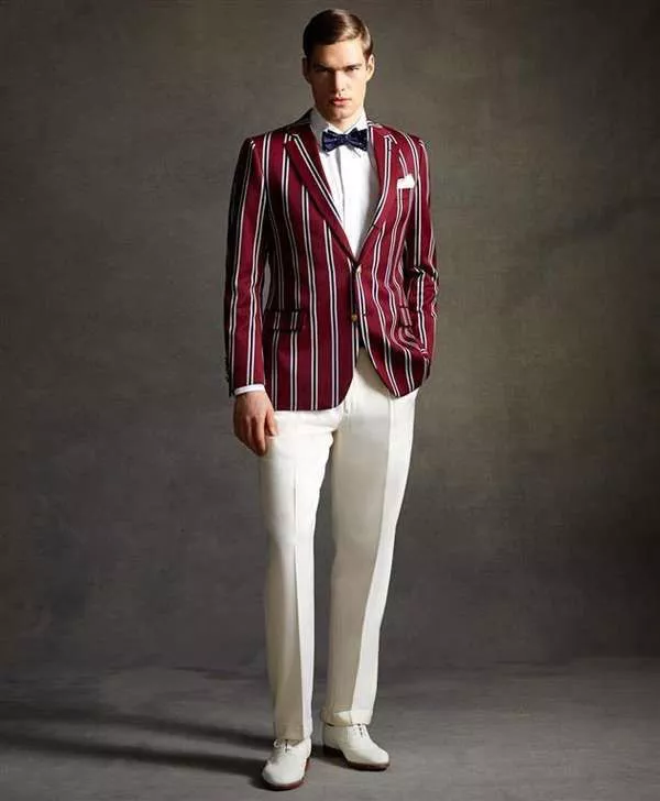 Модель в белых брюках со стрелками, белой рубахой, бордовом пиджаке в вертикальную полоску,бабочка