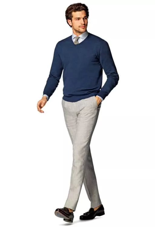 Модель в светлых зауженных брюках и синем свитере, деловой стиль