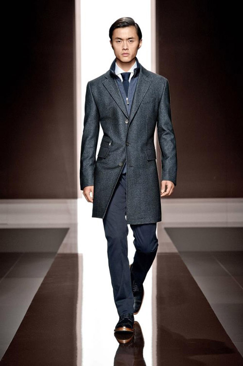 Молодой человек в деловом костюме и сером пальто