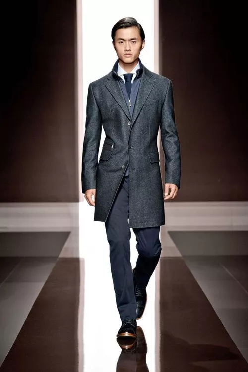 Молодой человек в деловом костюме и сером пальто