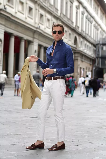 Модель в белых брюках с коричневым ремнем, синяя рубашка и пиджак
