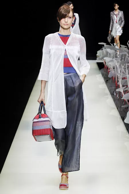 Модель в широких серых брюках, красно-синяя кофточка и белый удлиненный кардиган