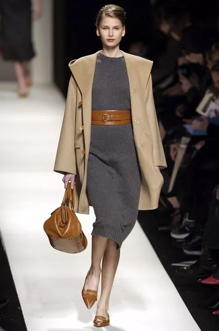 Модель в вязанном сером платье-миди, бежевое пальто прямого кроя и коричневые аксессуары
