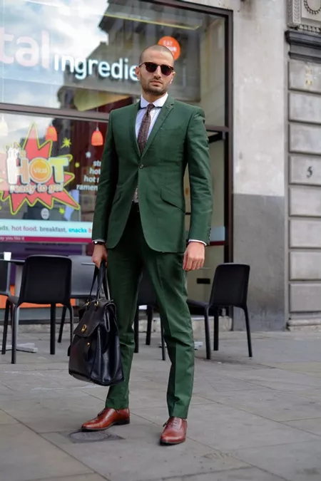 Модель в зеленом костюме, белой рубашкой, лалстук, большая кожанная сумка