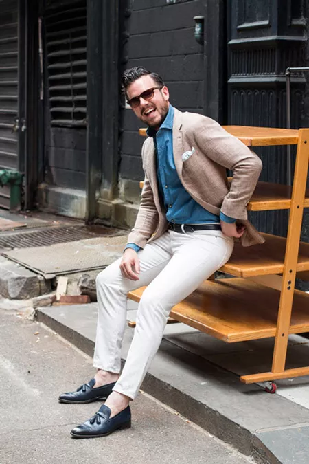 Молодой человек в белых брюках, синяя рубашка и светлый пиджак