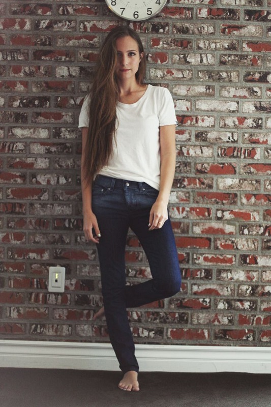 Девушка в темных джинсах и белой футболке