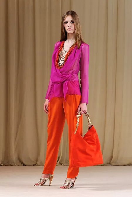 Девушка в блузке цвета фуксии и оранжевых штанах
