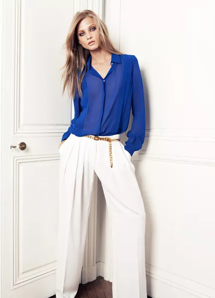 Девушка в синей блузке и белых брюках