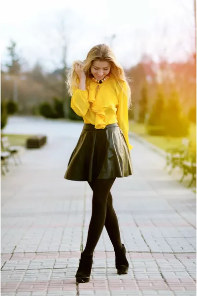 Девушка в желтой блузке и черной кожаной юбке