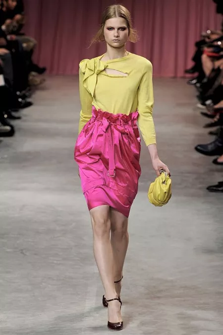 Модель в желтой блузке и розовой юбке
