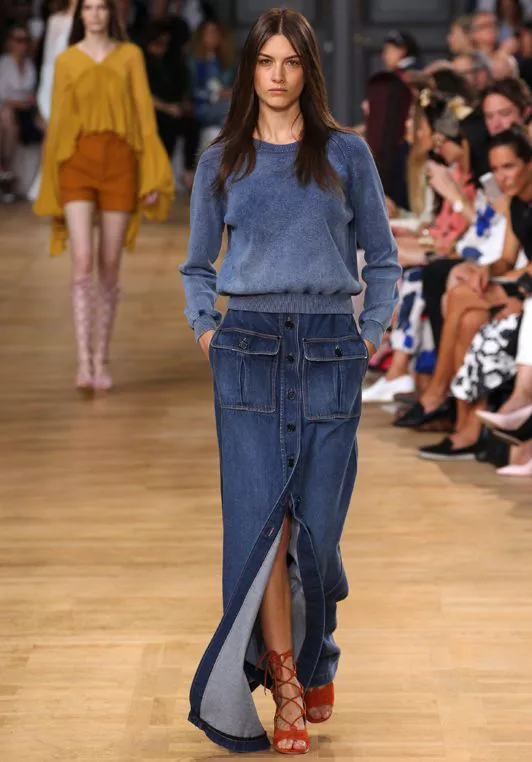 Девушка в длинной джинсовой юбке с пуговицами и свитере