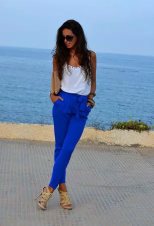 Девушка в синих брюках и белом топе