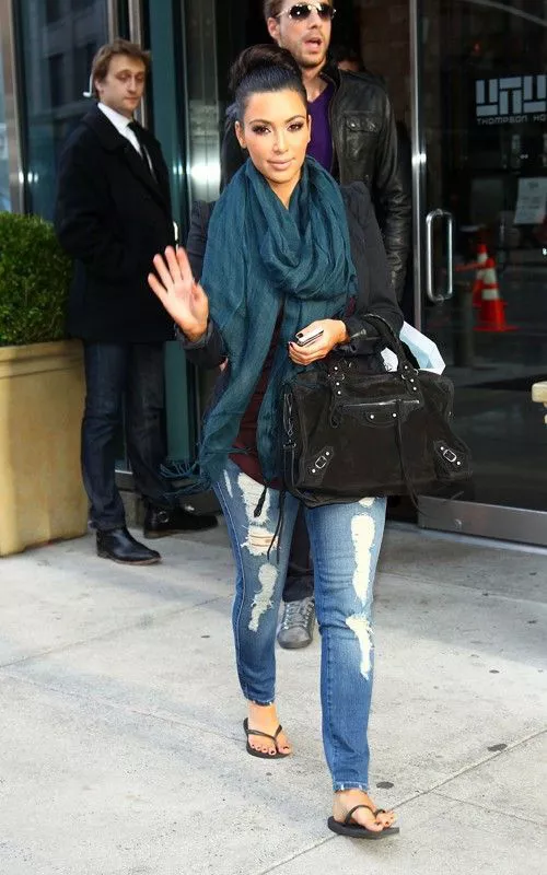Ким Кардашьян в рваных джинсах, сланцах и шарфом хомутом на шее