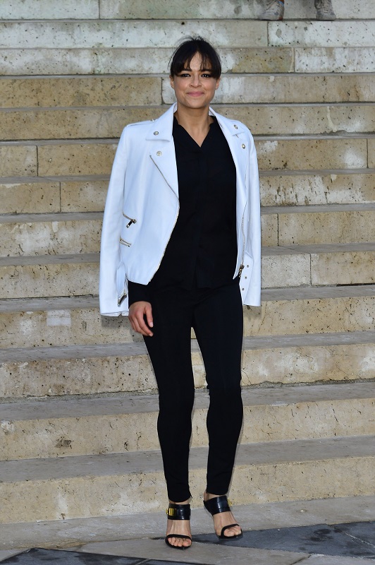 Мишель Родригес в черных штанах и белой куртке