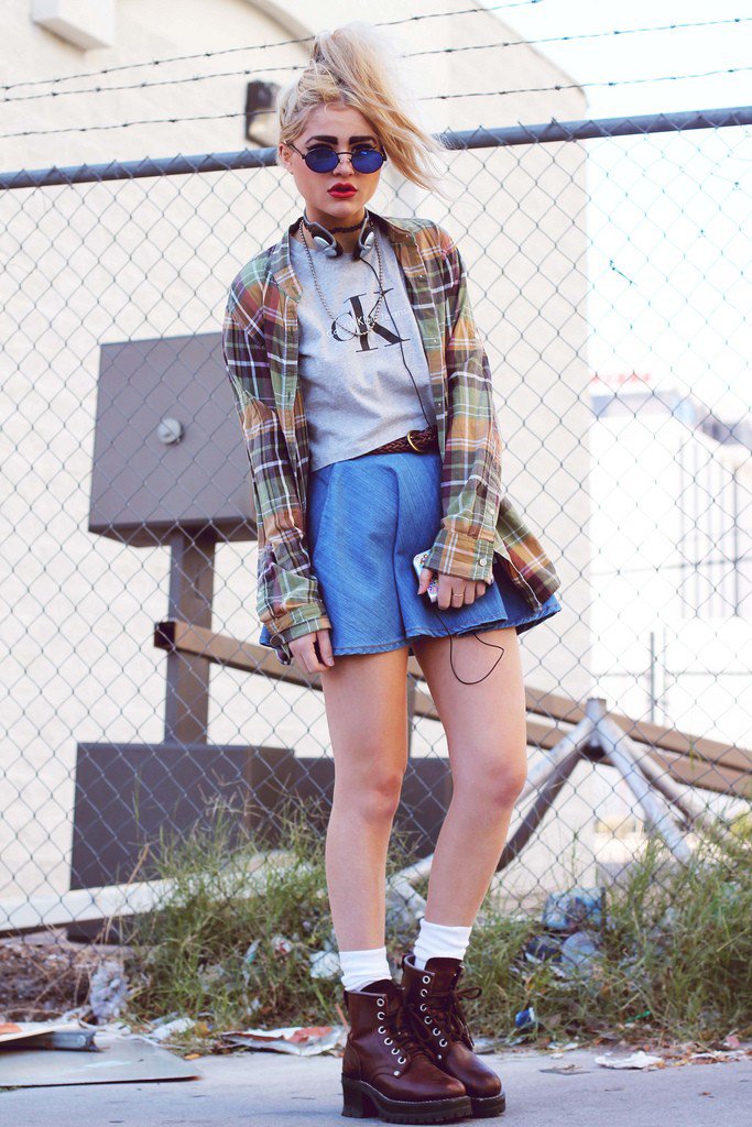 Девушка в короткой голубой юбке, серой футболке и рубахе в клетку, коричневые ботинки в стиле гранж