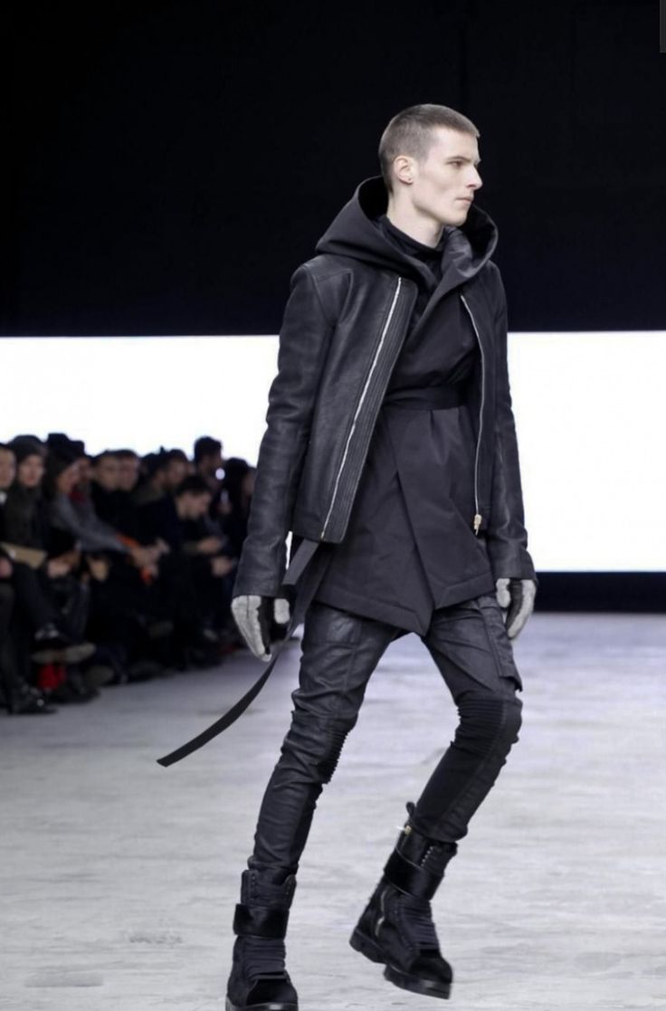 Модель в черных узких брюках и кожанной куртке