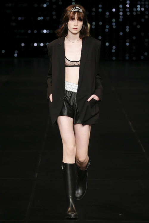 Образ в стиле гранж, модель в черных мини шортах, удлиненный пиджак и резиновые сапоги
