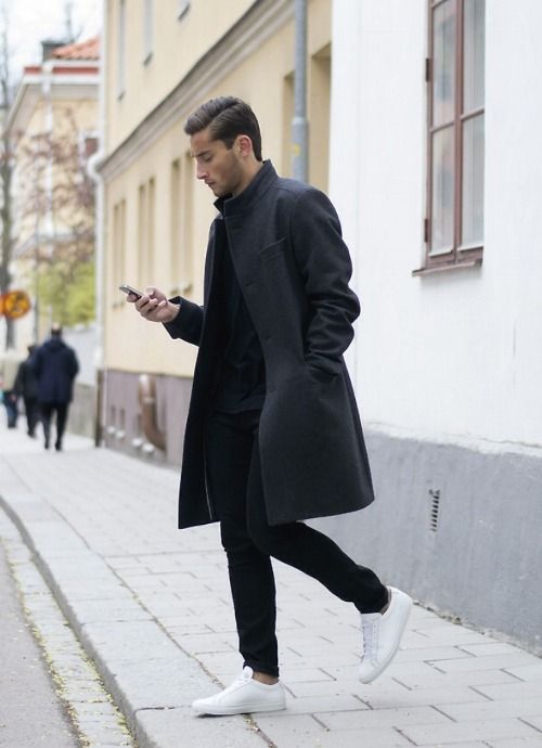 мужчина в белых кедах и черном пальто