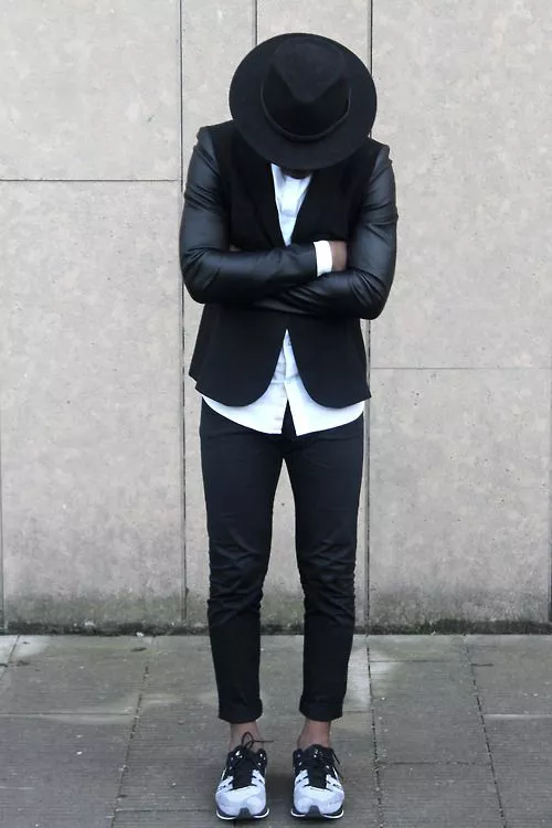 мужчина в черном пиджаке, кроссовках и шляпе