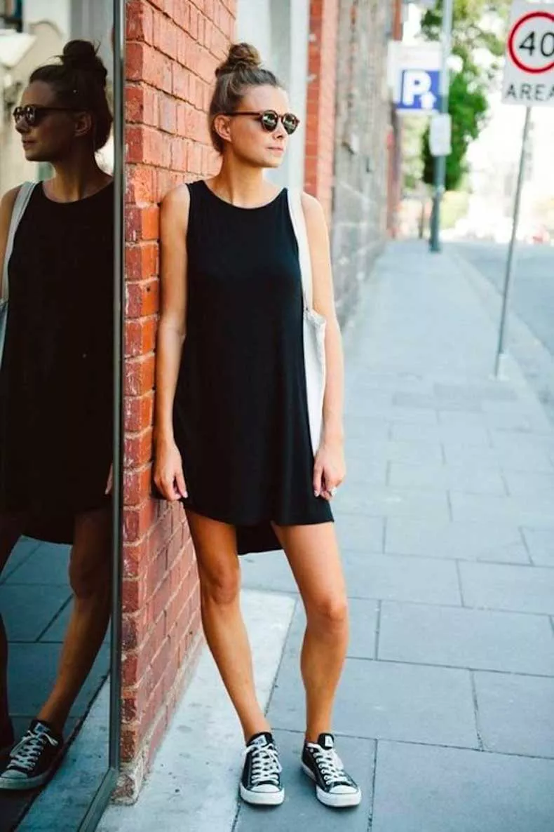 Девушка в коротком черном платье и кедах