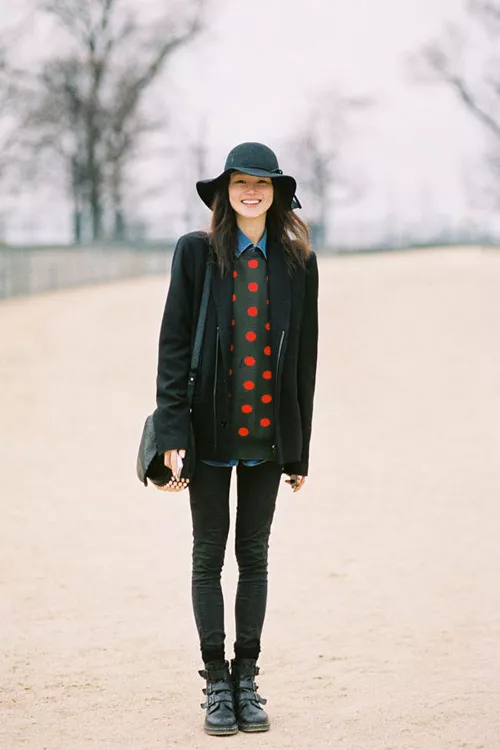Девушка в свитере в горошек и черном пальто