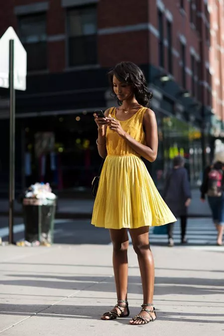 Девушка в желтом платье и серых сандалиях