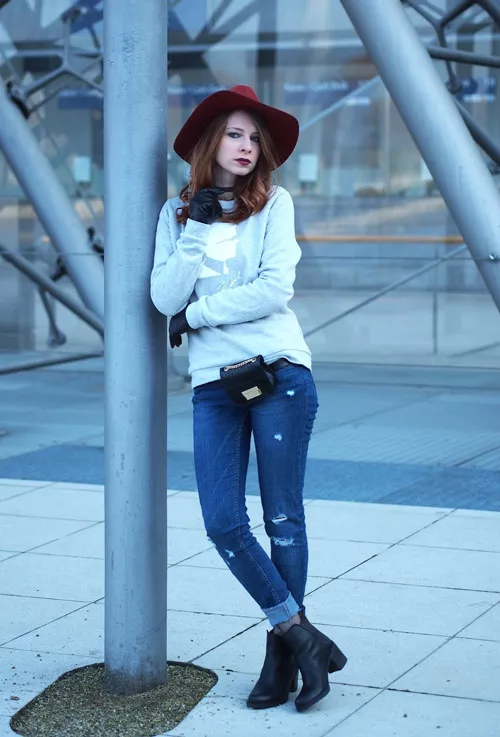 Девушка в джинсах, сером свитшоте и шляпе