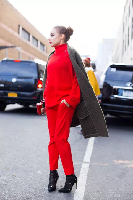 Девушка в красных брюках, свитере и коричневое пальто