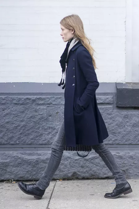 Девушка в серых джинсах, черные ботинки и пальто