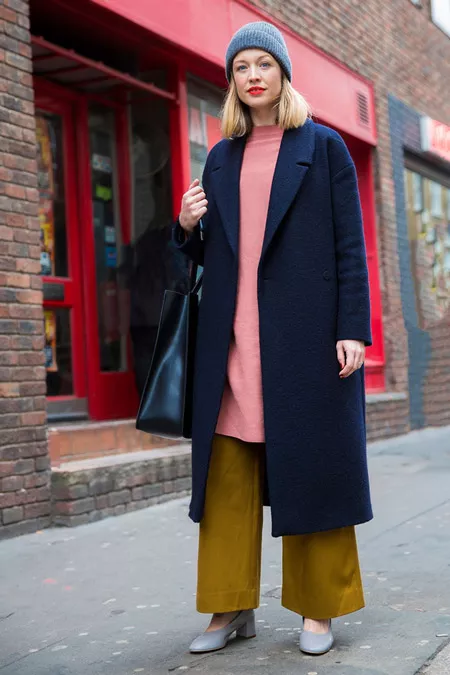 Девушка в широких брюках, розовой тунике и длинном темном пальто, серая шапка, неделя моды - Лондон осень/зима 2016-2017