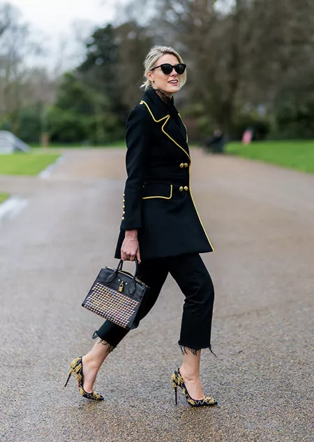 Модель в черных обрезанных брюках, черный кардиган с желтой оконтовкой, туфли на шпильке, неделя моды - Лондон осень/зима 2016-2017