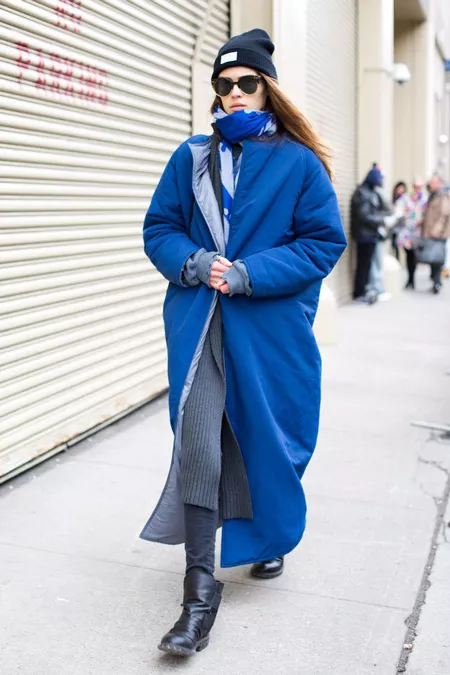 Модель в длином синем пальто, шарф и шапка