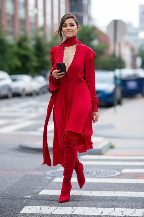 Девушка в красном ассиметричном платье и ботфортах