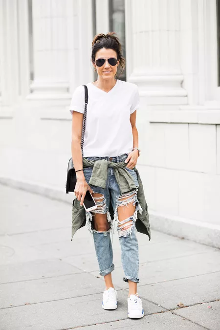 Девушка в рванных джинсах и белой футболке, кроссовки