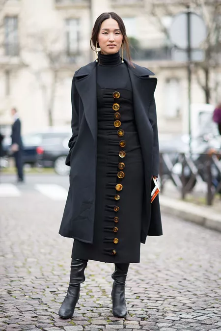 Модель в черном сарафане на пуговицах, черная водолазка и пальто