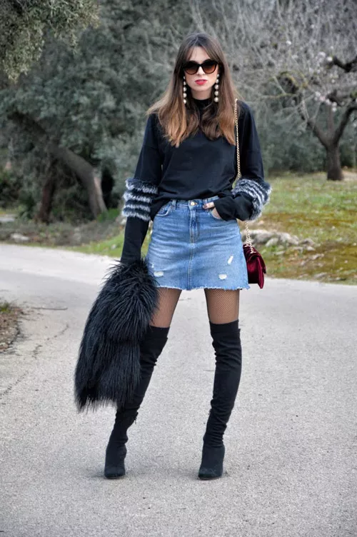 Девушка в джинсовой мини юбке, ботфортах и свитере