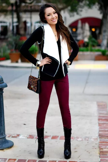 Девушка в черной куртке и бордовых джинсах