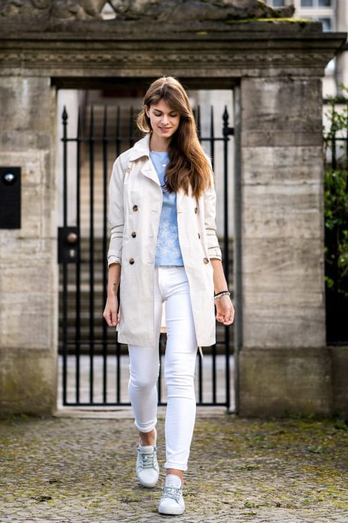 Девушка в белых джинсах, кедах и светлом тренче