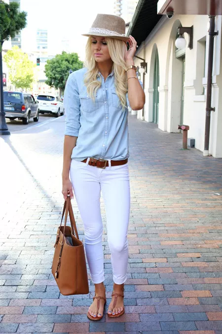 Девушка в белых джинсах, голубой рубашке и с коричневой сумкой тоут