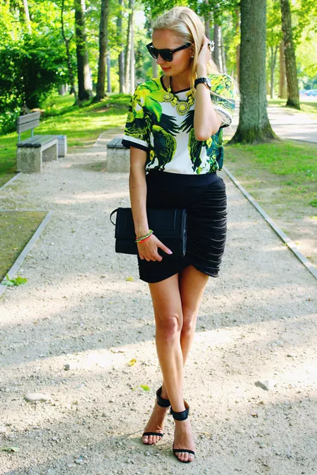 Девушка в блузе с тропическим принтом и черной узкой юбке