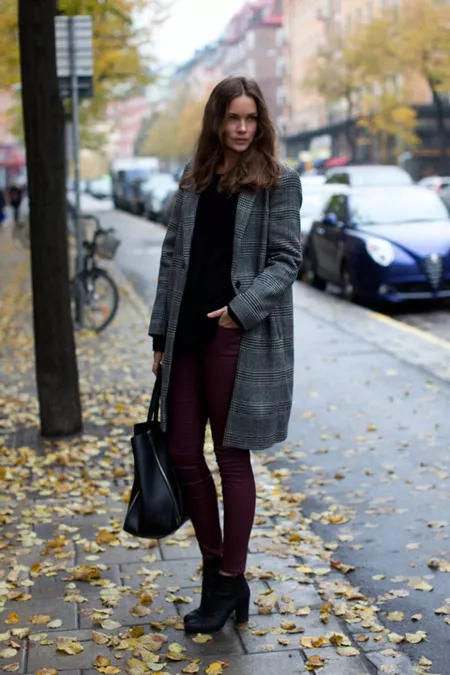 Девушка в бордовых брюках и темном пальто