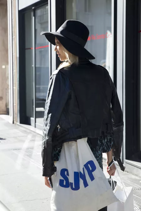 Девушка в черной косухе, шляпа и белая сумка тоут