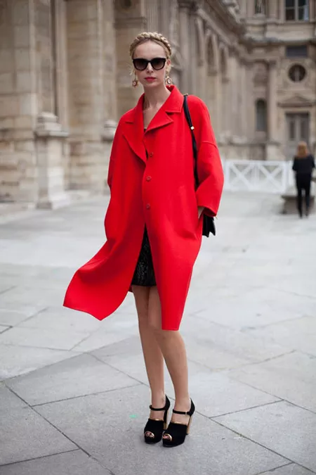 Девушка в черных босоножках и красном пальто