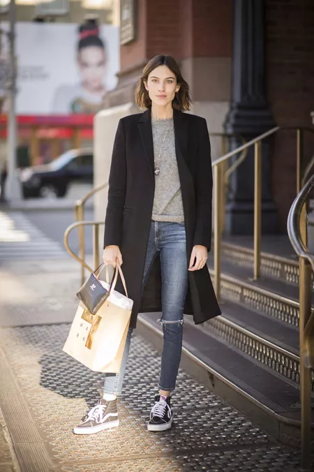 Девушка в джинсах, серый джемпер, черное пальто и бежевая сумка тоут