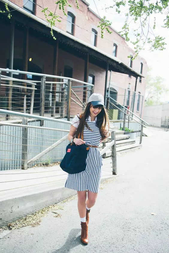 Девушка в полосатом платье, кепка и синяя сумка тоут