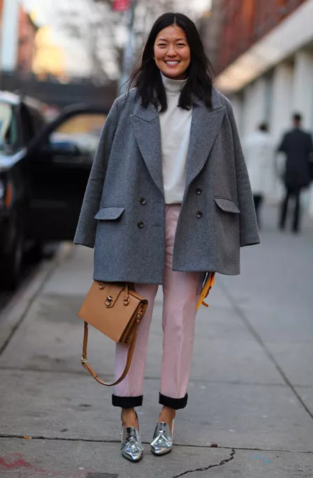 Девушка в розовых брюках и светлом пальто
