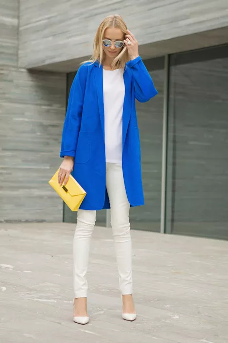 Девушка в белых брюках и синем пальто